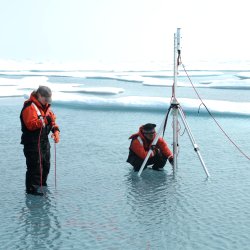 At work under the ice. The team of researchers is measuring the light transmittance below the ice in the Arctic.