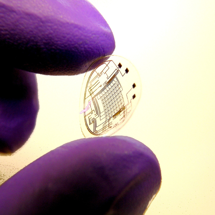 A contact lens with integrated circuitry. A researcher of the University of Washington holds a contact lens which embeds LEDs and other electrical components and which is manufactured using their newly developed self-assembly technique.