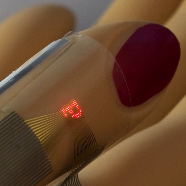 Wrappable ILED display. The micro-ILED display is printed on a thin sheet of plastic and wrapped around a mannequin finger.